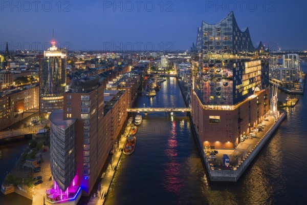 Aerial view of the Elbphilharmonie at blue hour with illuminated windows and view over the Speicherstadt and Hafencity, Hamburg, Germany, Europe