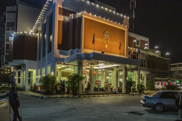 Customers around the entrance of a the Mangcome Hotel at night in Chiang Rai, Thailand, Asia
