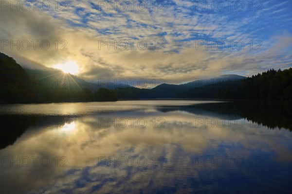 Sunbeams at sunrise over lake, landscape in morning light, summer, Rursee, Obersee, Rurberg, Simmerath, Eifel National Park, North Rhine-Westphalia, Germany, Europe