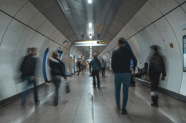 Tourists and commuters navigating an underground corridor in london, united kingdom, surrounded by modern architecture and vibrant energy