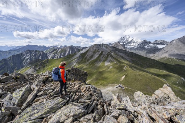 Mountaineer on the summit of Kastenegg, view of picturesque mountain landscape with snow-covered summit of the Großglockner, Vienna High Trail, Schober Group, Hohe Tauern National Park, Carinthia, Austria, Europe