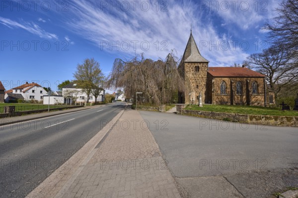 Protestant church Volmerdingsen, wall, bare winter trees, lawn, modern apartment building, general architecture, pavement, concrete paving stones, blue sky, cirrostratus clouds, intersection Volmerdingsener Straße with Pfarrer-Dustmann-Straße, Bad Oeynhausen, Mühlenkreis Minden-Lübbecke, North Rhine-Westphalia, Germany, Europe