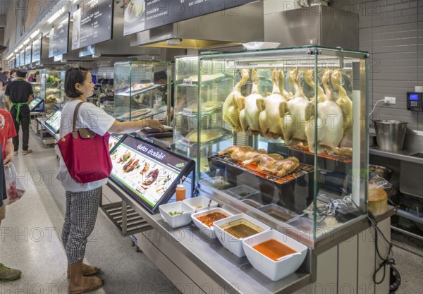 Thai woman ordering food in the cafeteria at the Big C Supercenter in Chiang Rai, Thailand, Asia