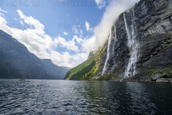 Geirangerfjord at the waterfall The Seven Sisters, tip of a red kayak in the fjord, atmospheric fjord landscape, first person view, near Geiranger, Møre og Romsdal, Norway, Europe