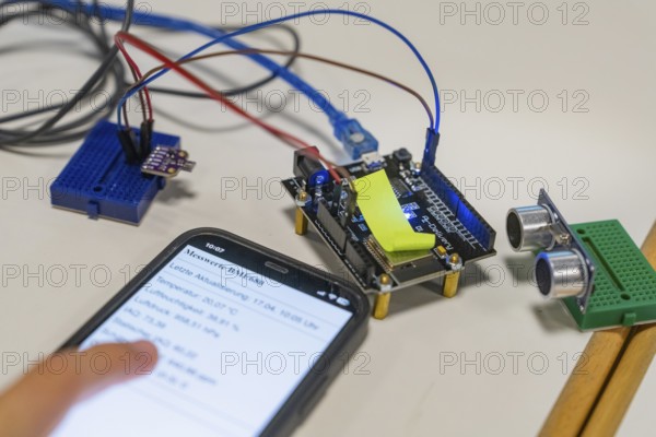Smartphone with displayed data next to an electronic setup on a table, Youth Research Centre Nagold, Germany, Europe