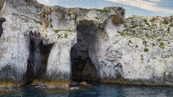 Rocky cave formations on the coast under a blue sky, boat trip around the island of Ortigia, Isola di Ortigia, Syracuse, Sicily, Italy, Europe