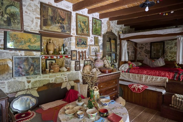 Niotis Restaurant, Rustic living room with antique furnishings, painted walls and paintings and a cosy bed in the corner, Kefalos, Kos, Dodecanese, Greek Islands, Greece, Europe