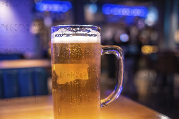 Cold beer waiting on the table in a lively london pub, inviting friends to enjoy a refreshing drink in a vibrant evening atmosphere