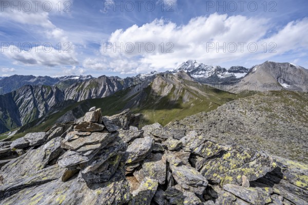 Cairn on the summit of Kastenegg, view of picturesque mountain landscape with snow-covered summit of the Großglockner, Vienna High Trail, Schober Group, Hohe Tauern National Park, Carinthia, Austria, Europe