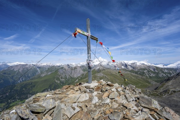 Böses Weibl summit with summit cross and colourful prayer flags, view of picturesque mountain landscape with snow-covered summit of the Großglockner, Wiener Höhenweg, Schober group, Hohe Tauern National Park, Carinthia, Austria, Europe