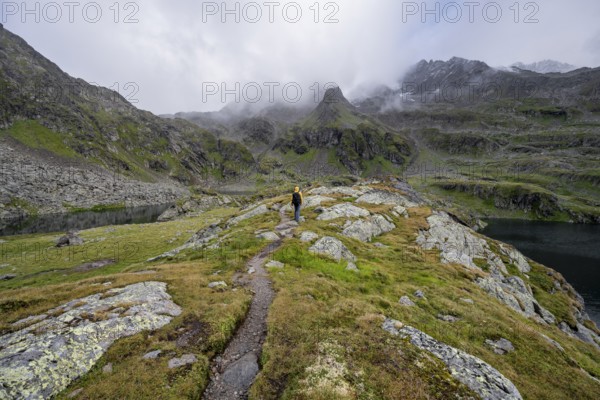 Mountaineers on a hiking trail between the mountain lakes Wangenitzsee and Kreuzsee, cloudy mountain peaks, Schober Group, Hohe Tauern National Park, Carinthia, Austria, Europe