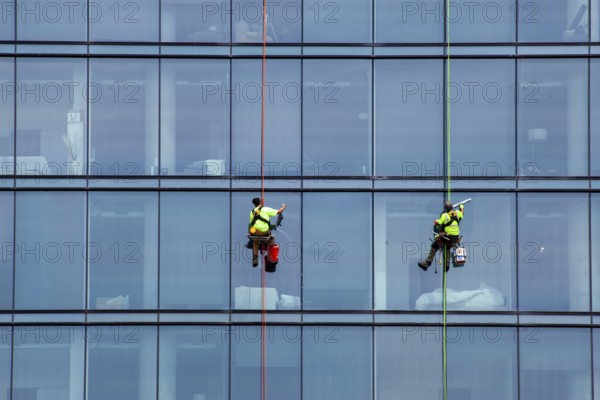 Detroit, Michigan - Window washers at the 25-story Residences Water Square luxury apartment building