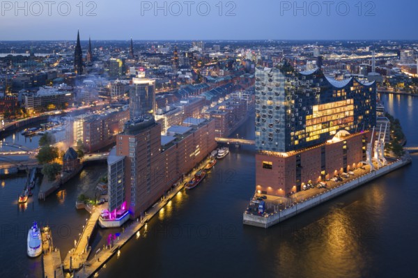 Aerial view of the Elbphilharmonie at blue hour with illuminated windows and view over the Speicherstadt and Hafencity, Hamburg, Germany, Europe