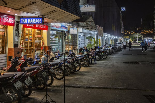 Massage parlor employees waiting for customers along a street in Chiang Rai, Thailand, Asia