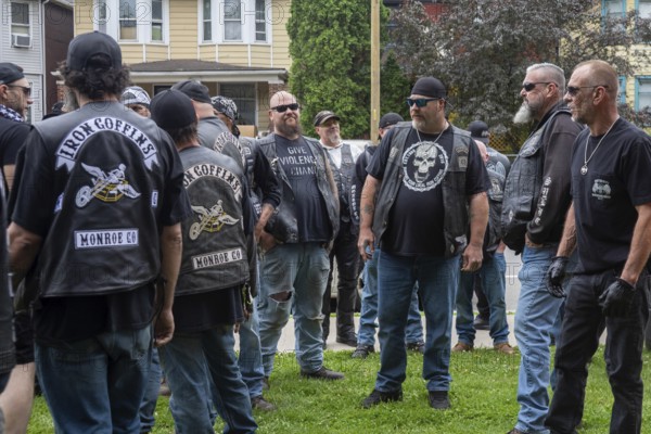 Detroit, Michigan USA - 14 June 2025 - Thousands gathered for a 'No Kings' rally, protesting President Trump's actions against immigrants and against democratic institutions. A group of antagonistic bikers showed, but were ignored except for one brief tussle. One man's shirt (center) said: Give Violence a Chance