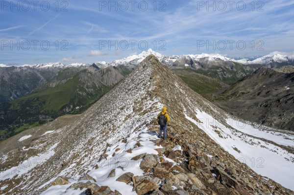 Mountaineer climbing to the summit of Böses Weibl, view of mountain landscape with snow-covered summit of the Großglockner, Wiener Höhenweg, Schober group, Hohe Tauern National Park, Carinthia, Austria, Europe