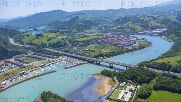 Aerial view of orio, a charming town in gipuzkoa, basque country, spain, showcasing the river, bridge, marina, and surrounding landscape on a sunny summer day