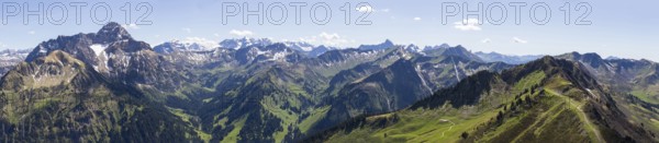 Sweeping panorama of the Alps with snow-capped mountains and green valleys under a blue sky, Kleinwalsertal, Austria, Europe