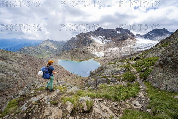 Mountaineer in rocky high mountain landscape, view of mountains with mountain lake Vogelhüttensee and glacier Übeltalferner, Stubai Alps, South Tyrol, Italy, Europe