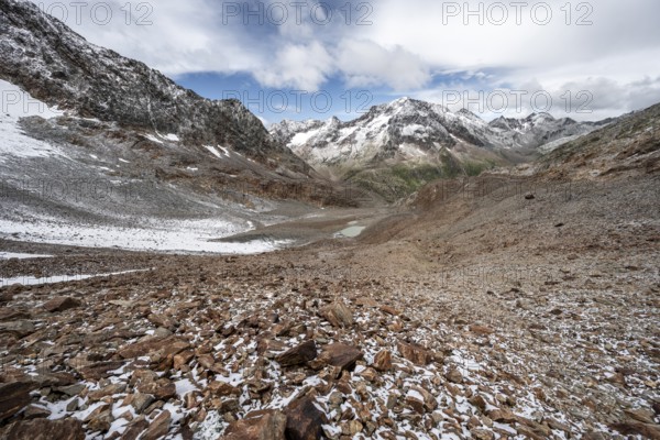 View of steep rocky mountain landscape with fresh snow in summer, descent from the Hornscharte, on the Wiener Höhenweg, behind summit Roter Knopf, Schober group, Hohe Tauern National Park, Carinthia, Austria, Europe