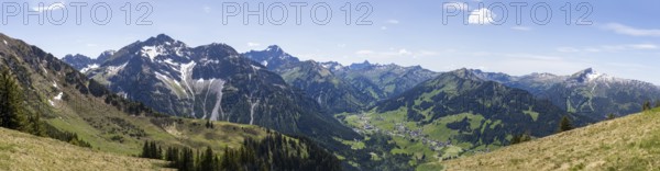 Sweeping panorama of the Alps with snow-capped mountains and green valleys under a blue sky with a view of the Hohe Ifen, Kleinwalsertal, Austria, Europe
