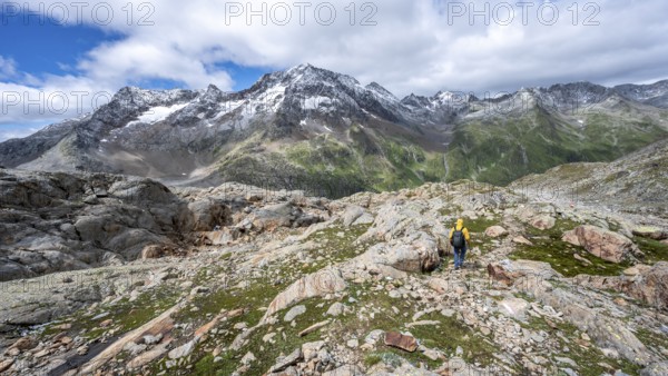 Mountaineer on hiking trail, rocky mountain landscape, behind mountain peak Roter Knopf with fresh snow in summer, descent from the Hornscharte on the Wiener Höhenweg, Schober group, Hohe Tauern National Park, Carinthia, Austria, Europe