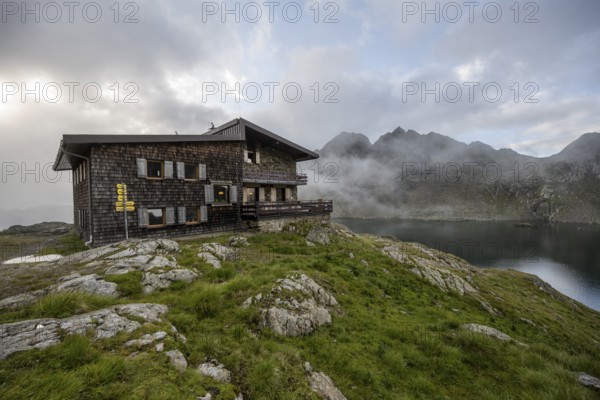 Mountain hut Wangenitzseehütte, cloudy mountain landscape with mountain lake Wangenitzsee, Wiener Höhenweg, Schober group, Hohe Tauern National Park, Carinthia, Austria, Europe
