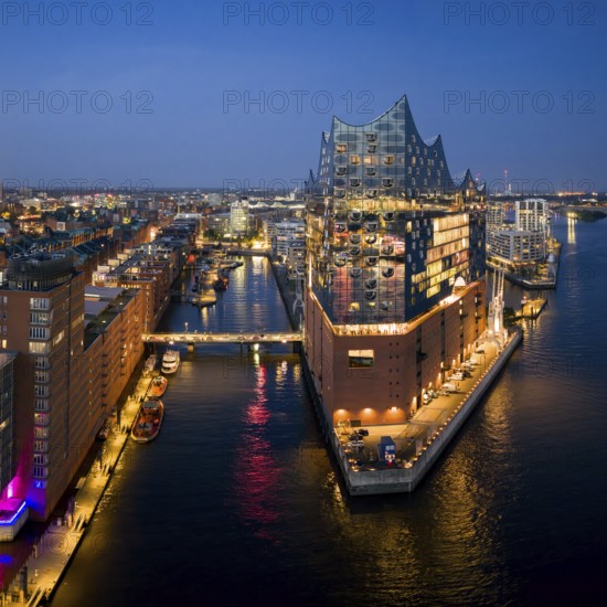 Aerial view of the Elbphilharmonie at blue hour with illuminated windows and view over the Speicherstadt and Hafencity, Hamburg, Germany, Europe