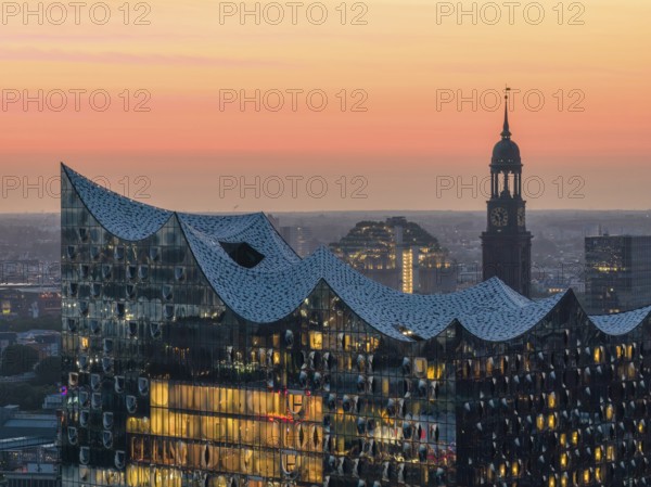 Aerial view of the Elbphilharmonie at sunset with illuminated windows and view over Hamburg and the main church St Michaelis (Michel), Hamburg, Germany, Europe