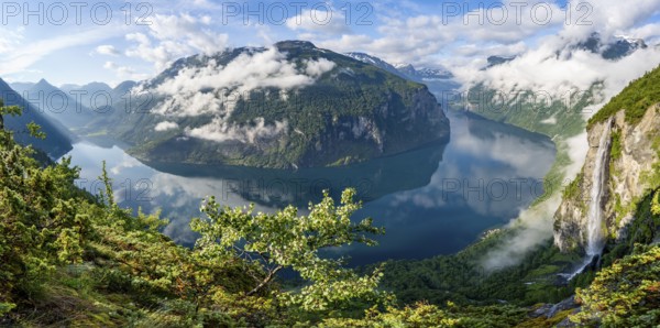 Panorama over the Geirangerfjord, Gjerdefossen waterfall, at Ørnesvingen viewpoint, atmospheric clouds over the fjord in the morning light, near Geiranger, Møre og Romsdal, Norway, Europe