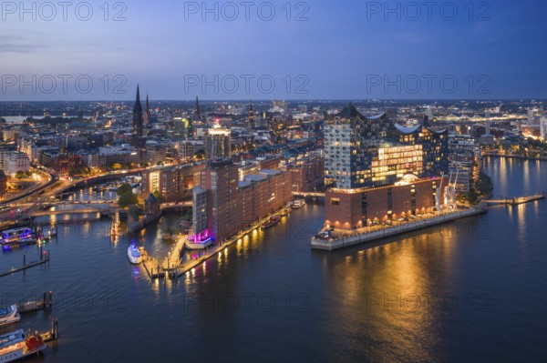 Aerial view of the Elbphilharmonie at blue hour with illuminated windows and view over the Speicherstadt and Hafencity, Hamburg, Germany, Europe