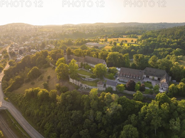 Wide aerial view of a monastery complex in a wooded landscape at sunset, event and wedding location Lorch Monastery, Lorch, Germany, Europe