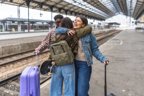 Students meeting at the train station are hugging each other after a long journey, happy to be reunited