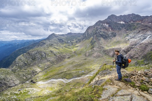 Mountaineer on a hiking trail, view of mountain landscape with Bodenbach, at the Treplitzerhütte, Stubai Alps, near Ridnaun, South Tyrol, Italy, Europe