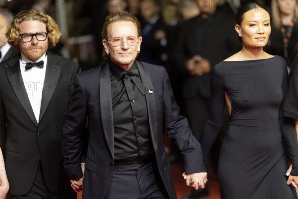 Cannes, France - 16.5.2024: Erik Messerschmidt, Bono, Kelly McNamara on the red carpet during the 78th Cannes International Film Festival. The 78th Cannes International Film Festival will take place from 13 to 24 May 2025