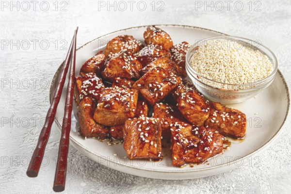 Fried pieces of salmon teriyaki with sesame seeds, top view