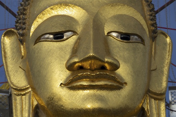 Face of a 32 metre high standing Buddha decorated with glass mosaics and 24-carat gold, Luang Pho To or Phrasiariyametri, Wat Intharawihan, Bangkok, Thailand, Asia
