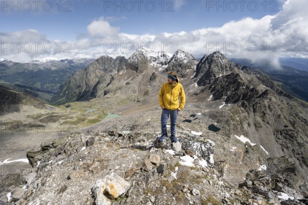 Mountaineer in rocky mountain landscape, at the summit of Keeskopf, behind summit of Petzeck, Hoher Perschitzkopf and Kruckelkopf, Schober group, Hohe Tauern National Park, Carinthia, Austria, Europe
