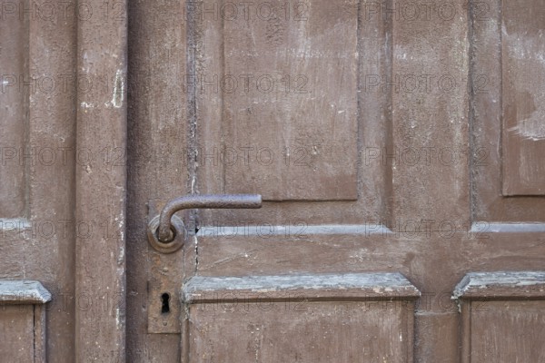 Weathered brown wooden door with rusty door handle and visible texture, Bad Bergzabern, Southern Palatinate, Palatinate, Rhineland-Palatinate, Germany, Europe