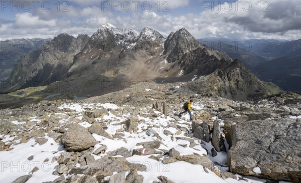 Mountaineer in rocky mountain landscape, descent from the summit of Keeskopf, behind summit of Petzeck, Hoher Perschitzkopf and Kruckelkopf, Schober group, Hohe Tauern National Park, Carinthia, Austria, Europe