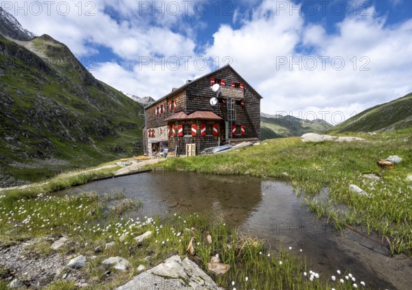 Elberfelderhütte mountain hut with small lake and cotton grass, in the upper Gössnitz valley, Vienna High Trail, Schober Group, Hohe Tauern National Park, Carinthia, Austria, Europe
