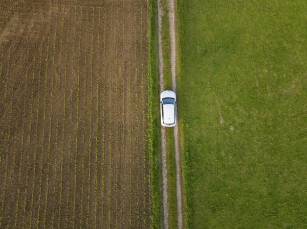 Car seen from the air on a narrow path between green and brown fields, Renault Megane, Deer E Carsharing, electric car, Calw, Black Forest, Germany, Europe