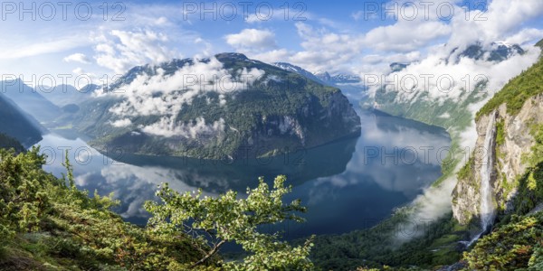 Panorama over the Geirangerfjord, Gjerdefossen waterfall, at Ørnesvingen viewpoint, atmospheric clouds over the fjord in the morning light, near Geiranger, Møre og Romsdal, Norway, Europe