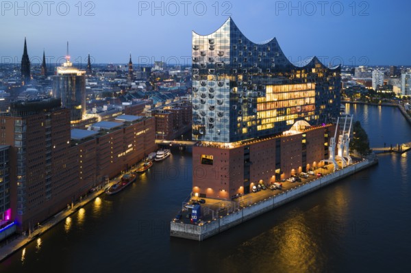 Aerial view of the Elbphilharmonie at blue hour with illuminated windows and view over the Speicherstadt and Hafencity, Hamburg, Germany, Europe