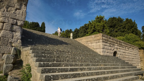 Stone staircase leads to a ruin surrounded by trees, a person climbs the steps, open staircase to the second terrace, Asklipion, Asklepieion, healing temple, temple, Hippocrates, Kos, Dodecanese, Greek Islands, Greece, Europe