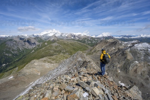 Mountaineer at the summit of Böses Weibl, view of picturesque mountain landscape with snow-covered summit of the Großglockner, Wiener Höhenweg, Schober group, Hohe Tauern National Park, Carinthia, Austria, Europe