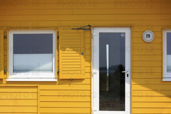 Yellow bungalow, holiday home, wooden house, facade detail with glass door and window, Insel Düne, offshore island of Heligoland, Schleswig-Holstein, Germany, Europe