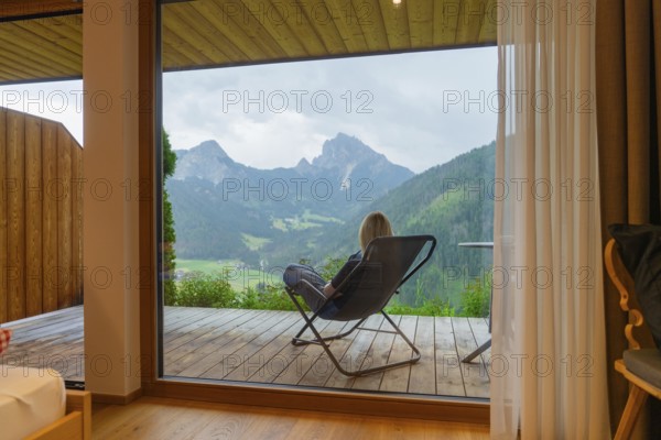 Cosy view from a window to the mountains, person sitting relaxed in an armchair, Dolomites, South Tyrol, Dolomites, Italy, Europe