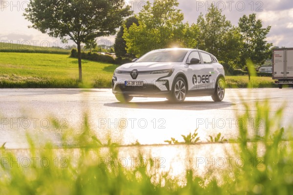 Car driving over a wet road, surrounded by green nature and trees, Deer E- CarSharing, Renault Megane electric car, Calw, Black Forest, Germany, Europe