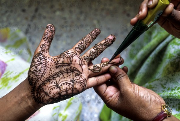 A woman showing mehandi henna applied on a girls hand, Tamil Nadu, South India, India, Asia